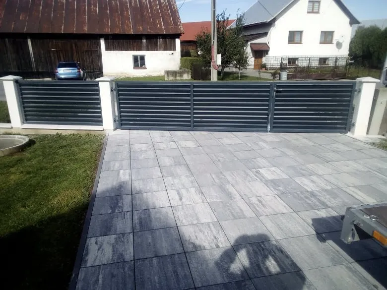 Lamelový plot s bránou medzi bielymi stĺpmi