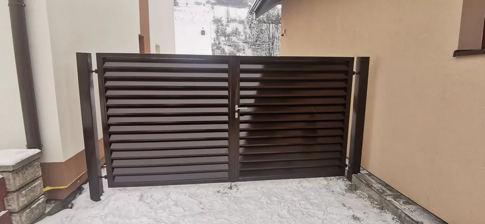 Hnedá žalúziová brána v snehu
